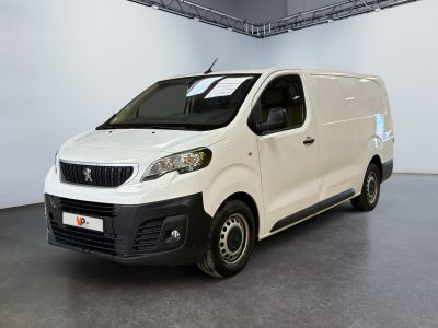 La camionnette blanche est garée dans la grande salle du bâtiment.