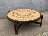une table en bois dont le plateau est orné d'un motif circulaire