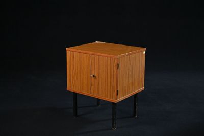 une image représentant une petite armoire en bois sur fond noir