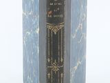 un livre bleu à la couverture noire posé sur une surface blanche
