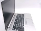 a silver laptop with a black keyboard on a white surface