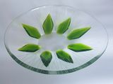 une plaque de verre ornée d'un motif de feuilles vertes