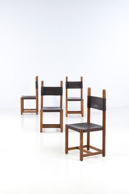 four chairs are lined up in a row on a white surface