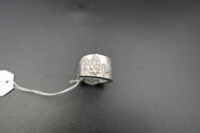 une bague en argent sertie d'un diamant, posée sur une surface noire