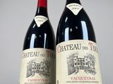 two bottles of red wine sitting next to each other on a table