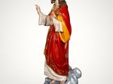 the statue of jesus is standing on a rock with a crown on his head