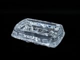 un objet en verre transparent posé sur une surface noire