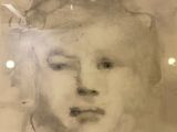 a drawing of a woman ' s face in a glass case