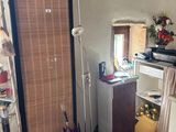 a room with a door, a mirror, a shelf, and a lamp
