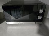 a black microwave sitting on a counter in a kitchen