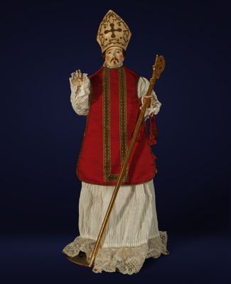 une image représentant une figurine d'un homme vêtu d'une tenue rouge et blanche et muni d'une canne