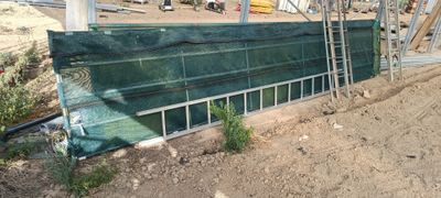 une photo d'un bâtiment en construction recouvert d'une bâche verte