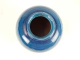 a blue vase that is sitting on a white table