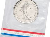 un gros plan d'une pièce de monnaie dans un sachet en plastique sur fond blanc
