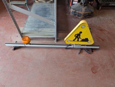 un panneau d'avertissement jaune posé par terre à côté d'une rampe