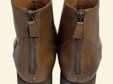 pair of brown leather boots with zippers on a white background