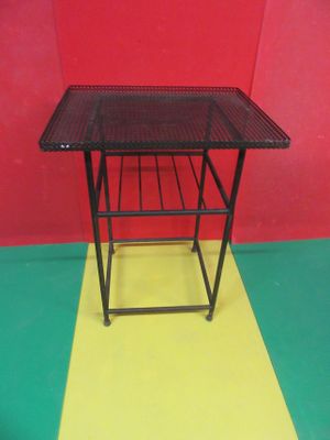 une petite table sur laquelle se trouve un panier, posée sur un sol jaune et rouge