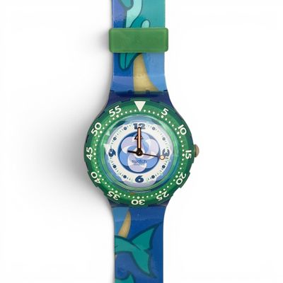 a close up of a watch on a white surface with a blue and green strap