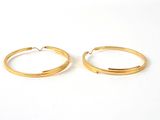 deux paires de boucles d'oreilles en or sur fond blanc
