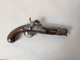 un vieux pistolet posé sur une surface blanche