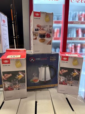 Trois boîtes de café sont empilées sur une table devant un réfrigérateur