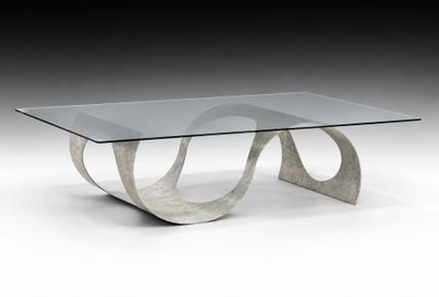 une table basse en verre avec un piètement métallique incurvé et un plateau en verre