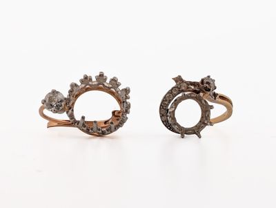 two gold rings with diamonds on them sitting next to each other