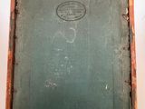 an old book is hanging from a wooden frame on a wall