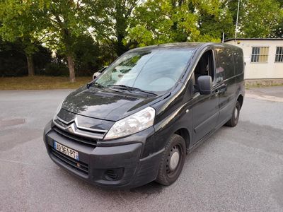 a black van parked in a parking lot with trees in the background