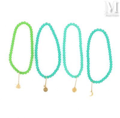 a set of four green bracelets with gold charms on them