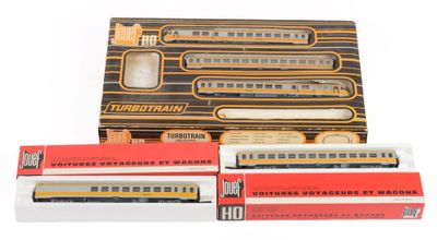 trois boîtes de petits trains jouets posées les unes à côté des autres sur une surface blanche