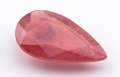 un gros plan d'un quartz rouge posé sur une surface blanche