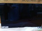 a black television sitting on top of a table next to a box