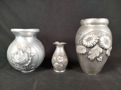three silver vases sitting next to each other on a black background