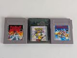 three nintendo game cartridges sitting next to each other on a white surface