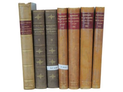 several old books are lined up in a row on a white surface