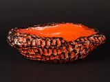 an orange bowl with black and white designs on it