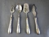 four pieces of silverware are laid out on a table