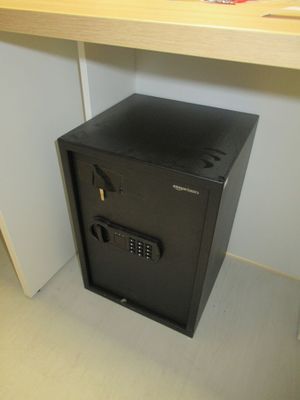 un petit coffre-fort noir posé sur un bureau dans une pièce