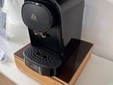 a black coffee maker sitting on a counter in a kitchen