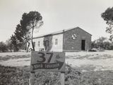 black and white photograph of a sign in front of a building