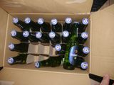 many bottles of beer in a cardboard box on the table