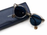 des lunettes de soleil dans un étui bleu sur fond blanc