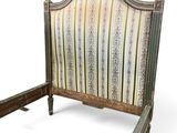 a bed that has a wooden frame with a striped headboard