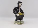 une petite figurine représentant un homme assis sur un tabouret