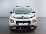 the front view of a white citrole parked in a room
