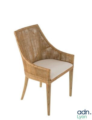 une photo d'une chaise en osier sur laquelle est posé un coussin