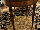 une table ovale avec un plateau en bois et une bordure dorée sur tout le pourtour