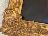 a gold frame with a picture of a woman in a black dress