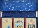 trois livres dans une boîte bleue posée sur une table en bois